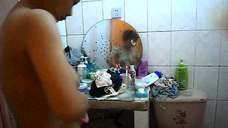 Voyeur spying on a busty mature Asian wife in the bathroom